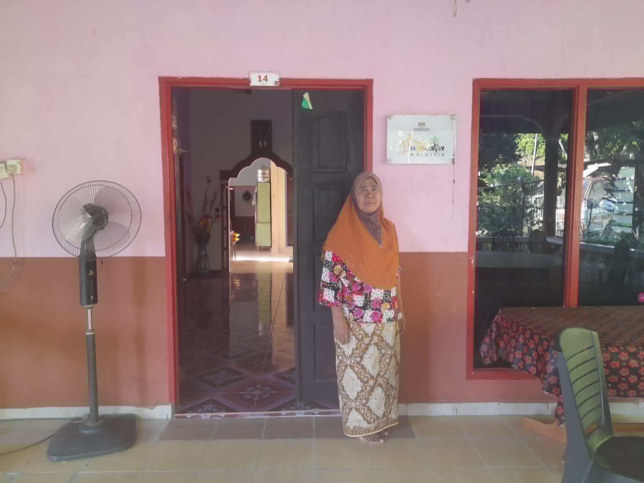 Host family welcoming guests at their kampung home